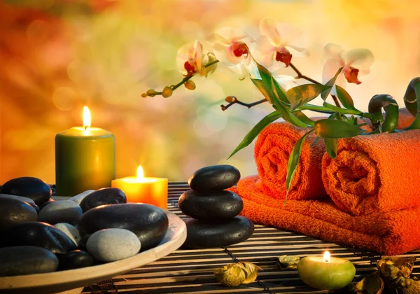 Förberedelse för massage i orange ljus och svarta stenar — Stockfoto