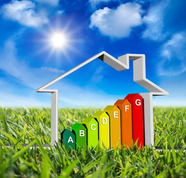House with energy classes - on green meadow and sun in blue sky — Stock Photo, Image