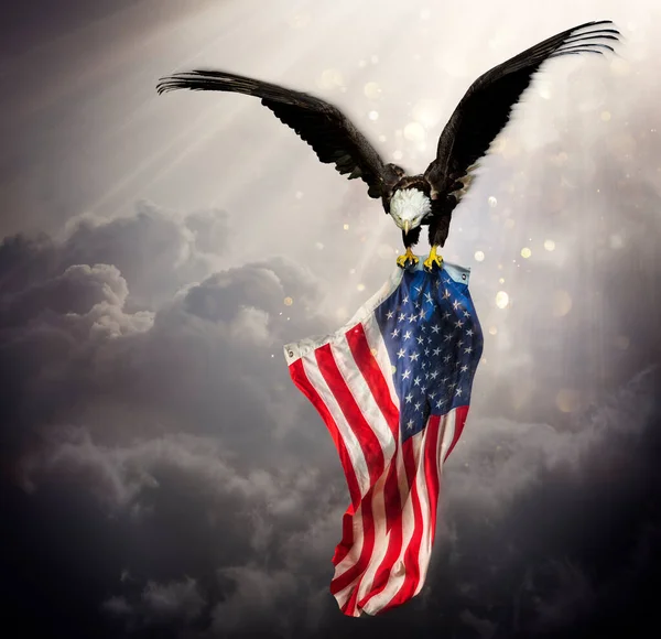 Eagle With American Flag Flies In The Sky With Blurred Bokeh And Sunlight Effect - Independence Day