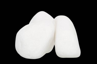             Üç beyaz taşın bileşimi, bu taşlar siyah arkaplandaki şeker taşlarını andırıyor, çekimin ön tarafından bir stüdyoda çekilmiş..                   