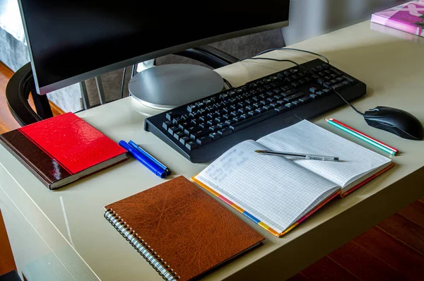 Bir öğrencinin iş yeri, kitaplar ve notlar bilgisayarla bir araya getirildiğinde bilgi edinmek için ideal bir kombinasyon oluşturur, gün ışığında bir ev odasında fotoğraf çekilir..