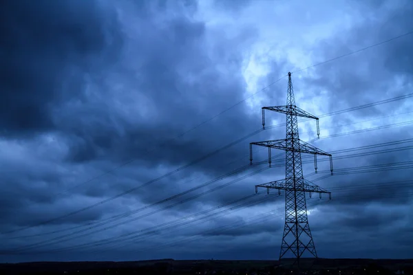 Poder poste en frente de un cielo de noche azul dramático —  Fotos de Stock