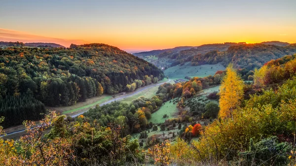 Almanya, bavyera kayalık jura dağlarda güzel bir ülke yolun yakınında renkli portakal altın ağaçları ile pastoral sonbahar sahne. kırsal kırsal harika bir açık gökyüzü sonbaharda gün batımı. — Stok fotoğraf