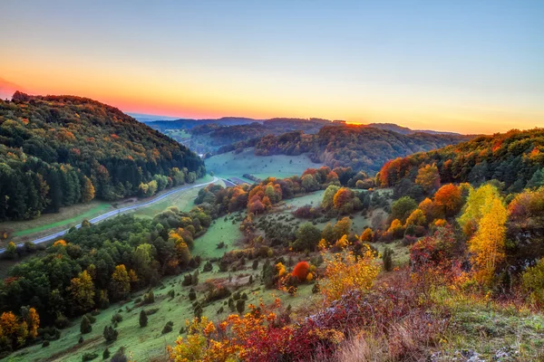 Idilli őszi táj a színes arany narancsfák közelében egy szép ország út a sziklás jura-hegység, a bavaria, Németország. őszi naplemente csodálatos tiszta az ég a az vidéki. — Stock Fotó