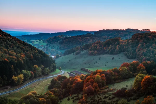 Paesaggio idilliaco autunnale con colorati aranci dorati vicino a una bella strada di campagna nelle montagne rocciose del Giura in Baviera, Germania. Tramonto in autunno con un meraviglioso cielo limpido nella campagna rurale . — Foto Stock