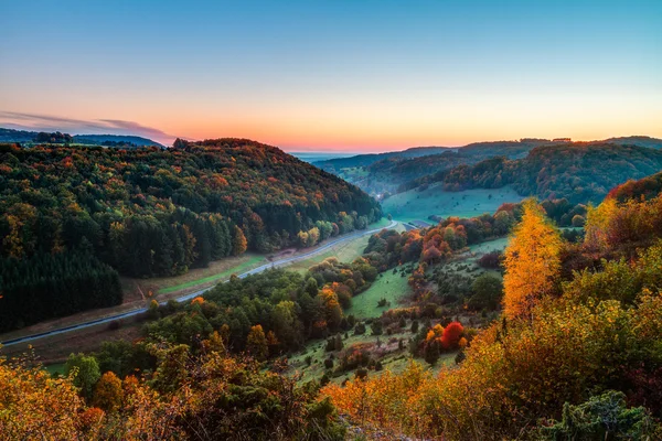 Sielskiej scenerii jesień kolorowy pomarańczowy złoty drzew w pobliżu drogi piękny kraj w skalistych gór jura, w Bawarii, Niemcy. zachód słońca w jesieni cudowne bezchmurne niebo w wiejskiej okolicy. — Zdjęcie stockowe