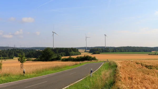 Ветряная электростанция в поле на закате — стоковое фото