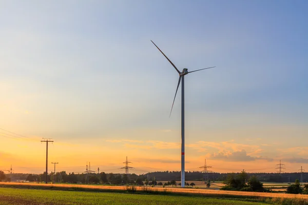 Ветряная электростанция в поле на закате — стоковое фото