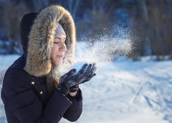 The girl inflates snow. — Stock Photo, Image