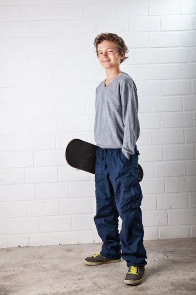 Cooler Junge und sein Skateboard — Stockfoto