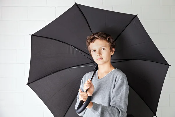 Teenage boy and a black umbrella — Stock Photo, Image