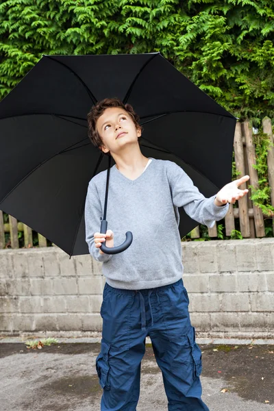 Teenage boy with umbrella waiting for rain — Stock Photo, Image