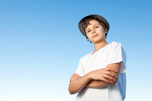 Hezký dospívající chlapec stojí venku proti modré obloze — Stock fotografie