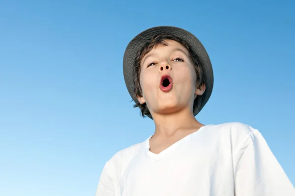 Hezký dospívající chlapec stojí venku proti modré obloze — Stock fotografie