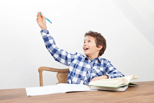 Um rapaz está a fazer os trabalhos de casa. — Fotografia de Stock