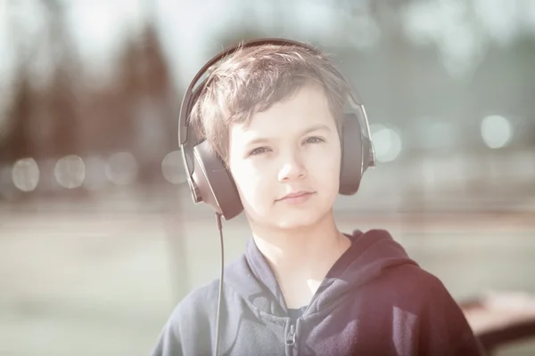 ヴィンテージのヘッドフォンで若い男の子を見てください。 — ストック写真