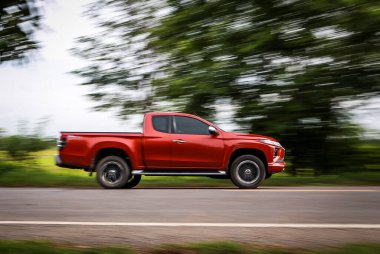 The automotive on the hometown road was taken photos by panning technique with a rice farm background. Panning car on the road photography.