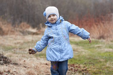 çam kozalağı ile doğada küçük kız