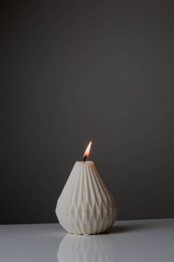 Cozy home interior decor, aromatic candles in glass glowingon white and grey background with natural oil, selective focus of fluffy bunny tail grass, brown jar, lotus flower candle, round matt ceramic