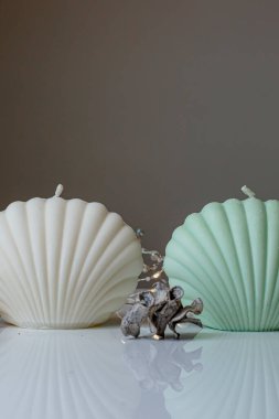 Ceramic pastel design round hole vases with seashell candles and soft aroma grass. Cozy home. Christmas decoration.