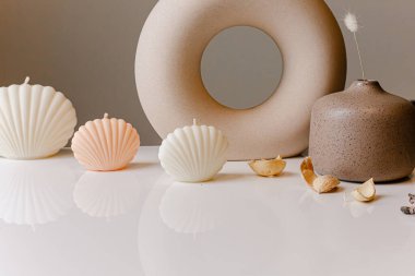 Ceramic pastel design round hole vases with seashell candles and soft aroma grass. Cozy home. Christmas decoration.