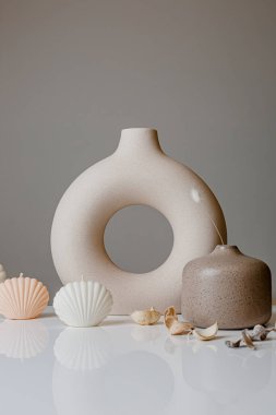 Ceramic pastel design round hole vases with seashell candles and soft aroma grass. Cozy home. Christmas decoration.