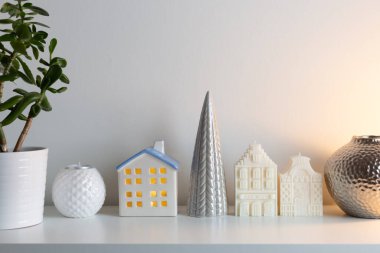 White candle dutch houses with ceramic christmas tree and glass round light lamp. Christmas home decorations. Happy holidays