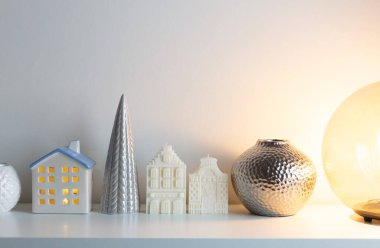 White candle dutch houses with ceramic christmas tree and glass round light lamp. Christmas home decorations. Happy holidays