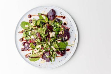Microgreen and arugula salad with tomato and balsamic sauce, almond, orange, lemon dressing. Summer dish. Healthy salad, leaves mix