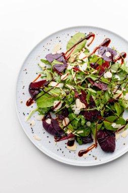 Microgreen and arugula salad with tomato and balsamic sauce, almond, orange, lemon dressing. Summer dish. Healthy salad, leaves mix