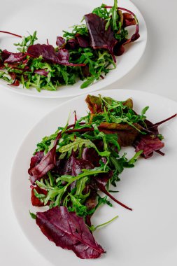Microgreen and arugula salad with tomato and balsamic sauce, almond, orange, lemon dressing. Summer dish. Healthy salad, leaves mix
