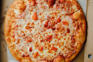 Pizza with champignons mushrooms, pepper and cheese on pizza box. View from above with copy space.