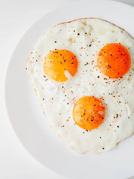 Three Fried Eggs Pepper Salt White Plate White Background — Stockfoto