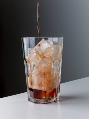 Buz küplü kola. Bir bardak kola. Uzayı kopyala Koyu arkaplanlı buzlu bardağa alkolsüz içecek dök. Buz izole edilmiş bir bardak kola. Soğuk dumanla kaplı buzlu içecek bardağı..