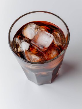 Cola with Ice Cubes. Glass of cola. Copy Space. Pour soft drink in glass with ice splash on dark background. glass of cola with ice isolated. Soft drink glass with ice splash on cool smoke background.