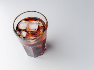 Cola with Ice Cubes. Glass of cola. Copy Space. Pour soft drink in glass with ice splash on dark background. glass of cola with ice isolated. Soft drink glass with ice splash on cool smoke background.