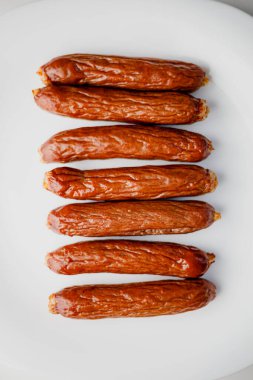 Grilled sausages on white plate, close-up. Grilling food, bbq, barbecue
