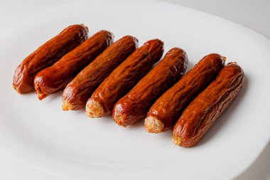 Grilled sausages on white plate, close-up. Grilling food, bbq, barbecue