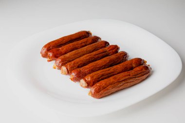 Grilled sausages on white plate, close-up. Grilling food, bbq, barbecue