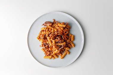 Fresh italian pasta with baby octopus. Close up of calamarata octopus italian traditional sicilian pasta homemade seafood sauce with tomato,basil,parsley,herbs,chilly.