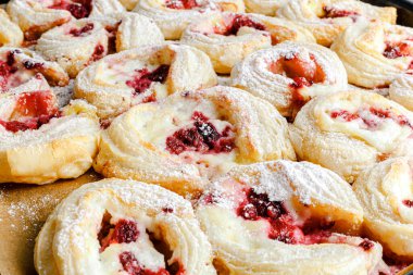 Fresh delicious puff pastry with sweet berries.  Puff pastry tart with raspberry and cream cheese mascarpone. Cream filling and sweet berry topping. Close-up baked goods. hands transfer hot buns with a baking oven on a plate.