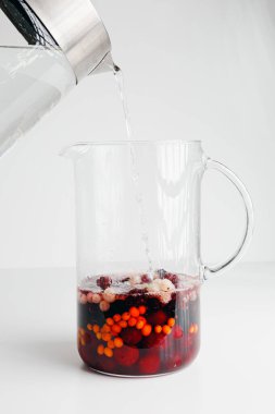 Homemade hot red wine sangria with orange, apple, cherry, raspberry. Hot sea buckthorn tea with ginger, white currant, honey, Vitaminic healthy. Immune system booster food, antiviral beverage.