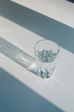 Glass of mineral filtered water and sunshine on white background including clipping path. 