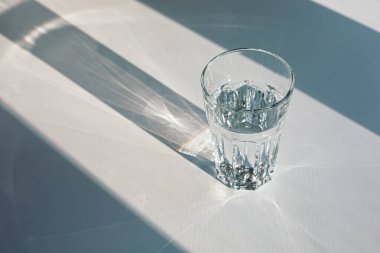 Glass of mineral filtered water and sunshine on white background including clipping path. 