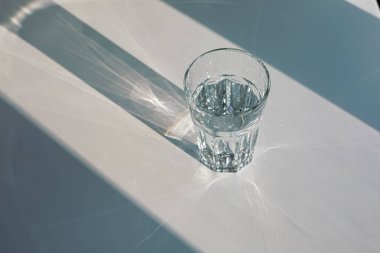 Glass of mineral filtered water and sunshine on white background including clipping path. 