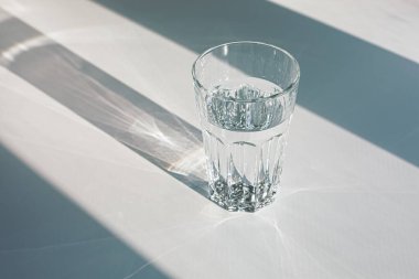 Glass of mineral filtered water and sunshine on white background including clipping path. 