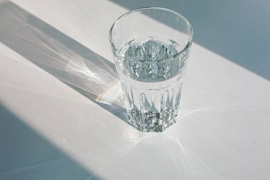 Glass of mineral filtered water and sunshine on white background including clipping path. 