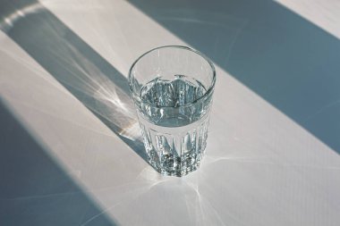 Glass of mineral filtered water and sunshine on white background including clipping path. 