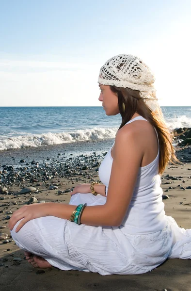 Девушка в белом платье сидит на пляже — стоковое фото