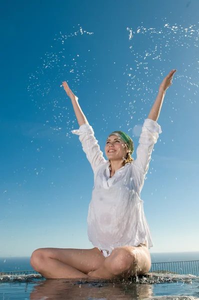 Woman sitting near the water Stock Photo